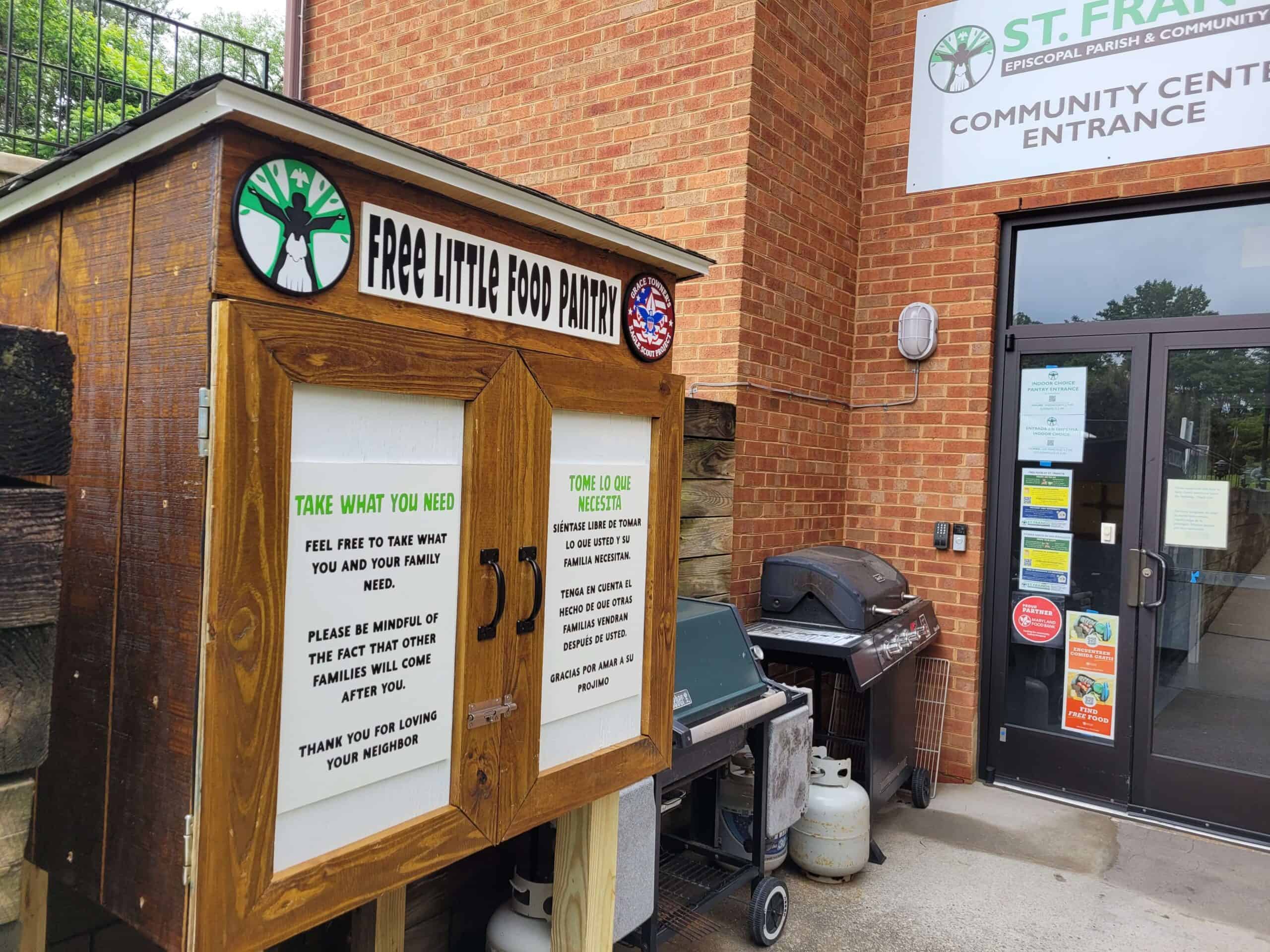 A small wooden pantry labeled "Free Little Food Pantry" is outside the St. Francis Community Center entrance, featuring donation guidelines.